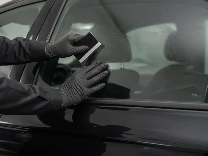 Window tint film applied with a squeegee (illustrative image)